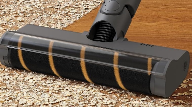 A close up of the Dreame R20 vacuuming up large particles on a hard floor