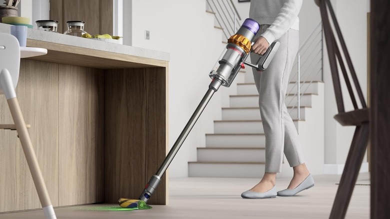 A woman vacuuming with the Dyson V15.
