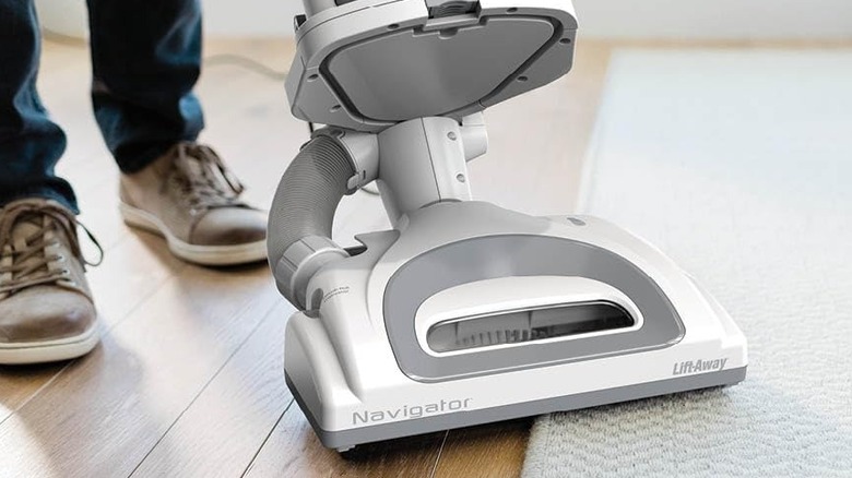 A close up of the Shark's large motorized head cleaning on the edge of a rug and hard flooring.