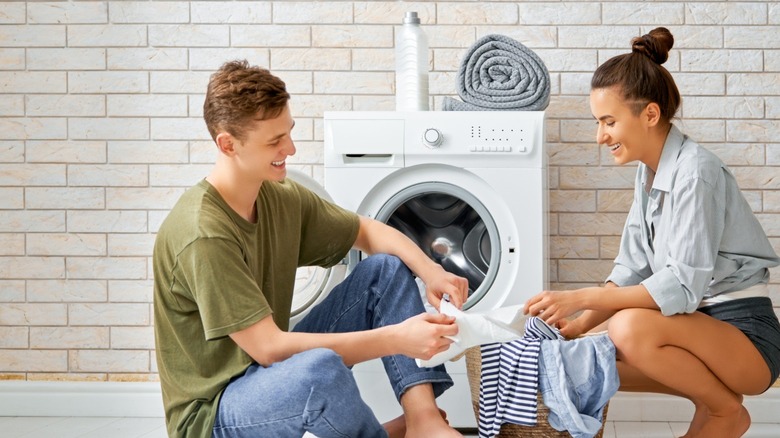 Young couple in front of small washer