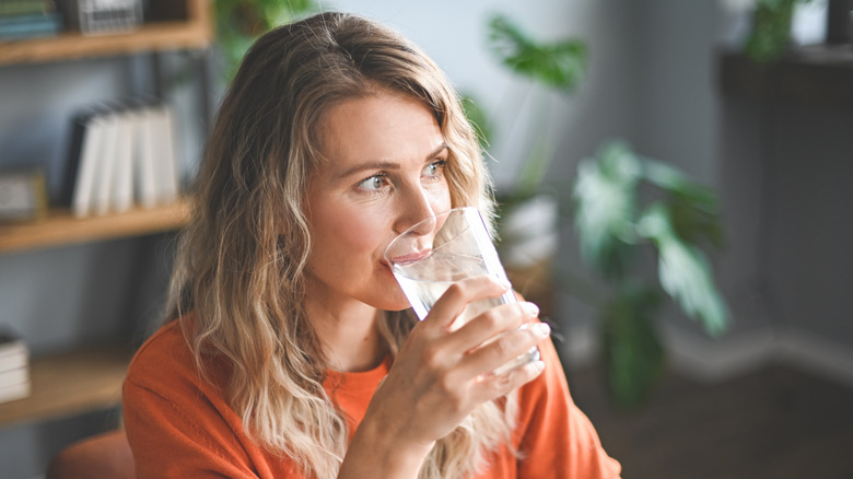 Woman thoughtfully drinking water