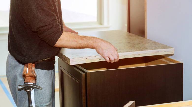 Man installing laminate countertop in the kitchen