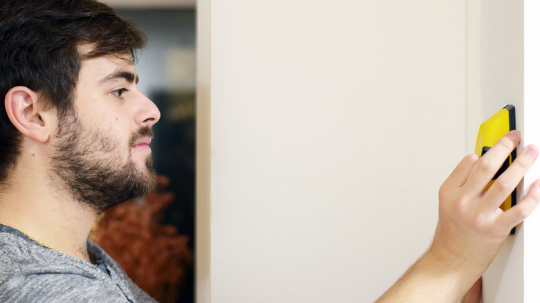 man using stud finder