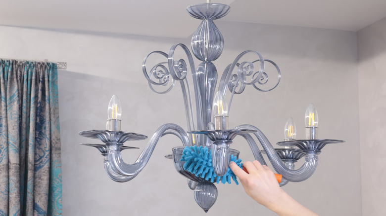 Woman's hand cleaning a glass chandelier