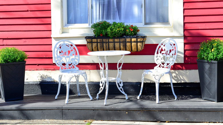 cast iron table and chairs under a window