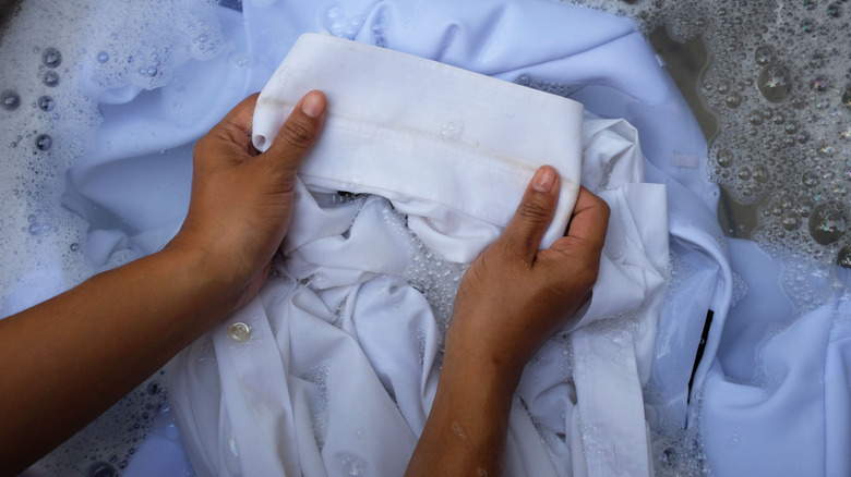 Person rinsing clothing in water