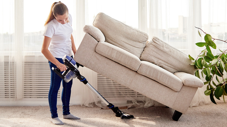 woman lifting sofa