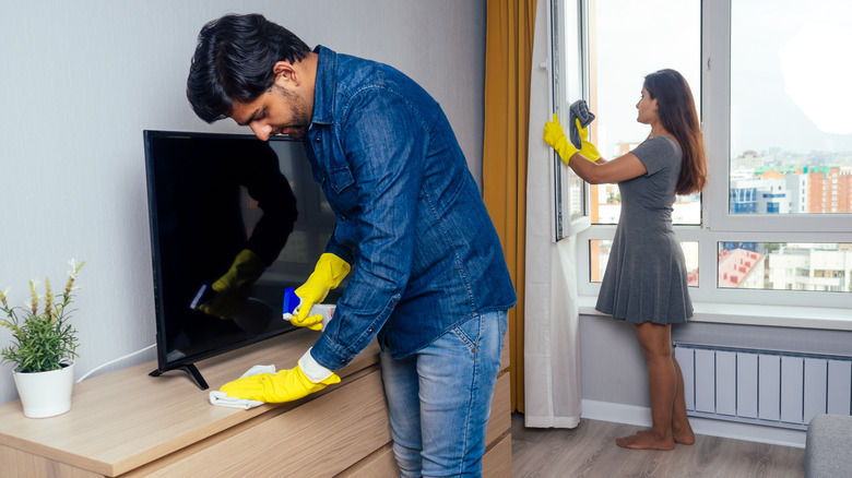 couple cleaning living room