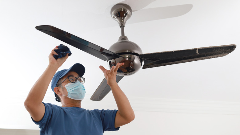 man cleaning ceiling fan