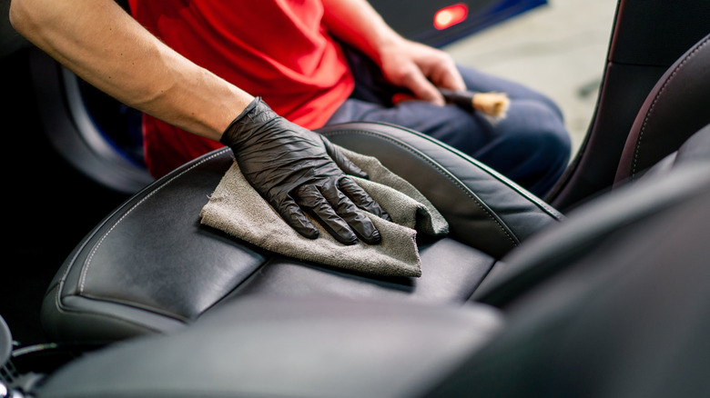 A man cleaning his car with a microfiber towel