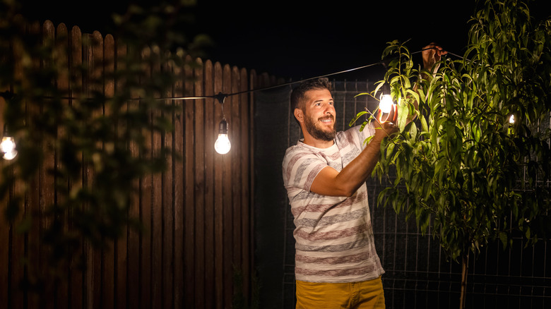 Man fixing outdoor string lights