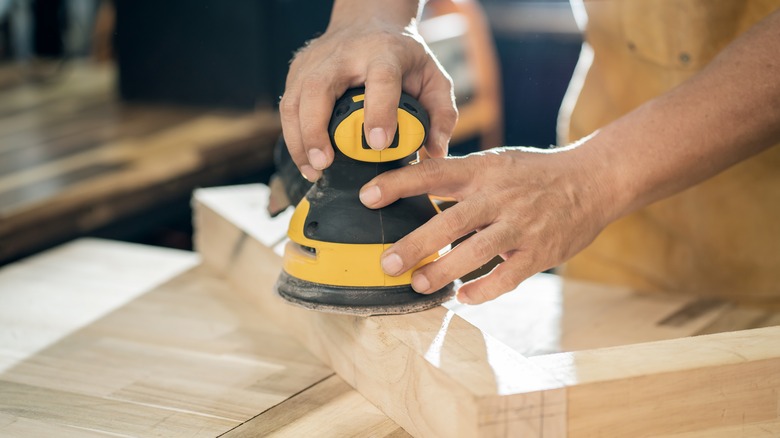 Person sanding with power sander