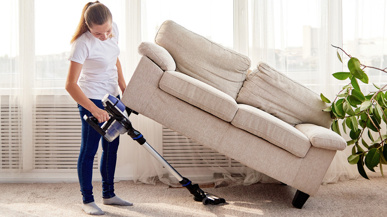 Cleaning under her couch