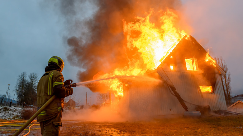 fireman spraying building flames