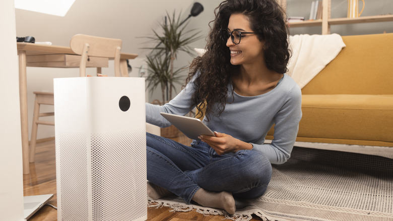 woman sitting near air purifier