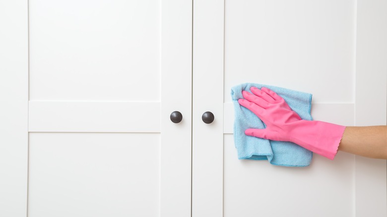 wiping cabinet with blue cloth