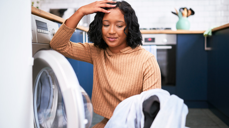 Woman looking at dirty laundry