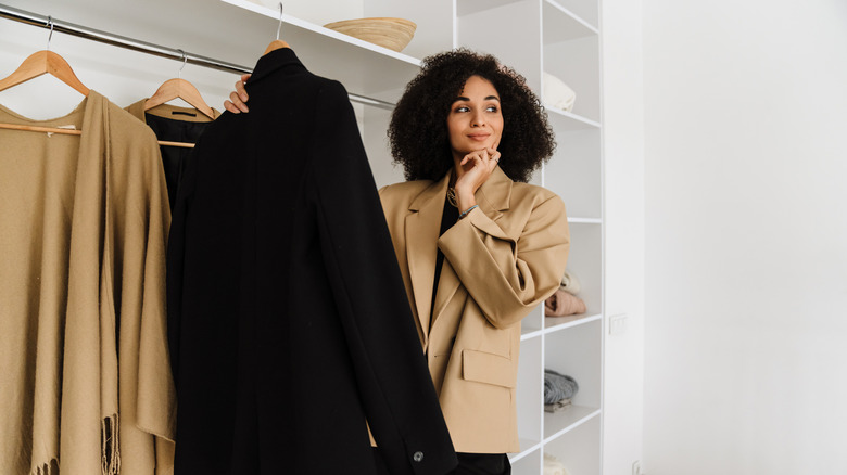 Woman holding jacket on hanger