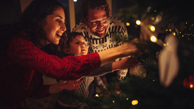 Family decorating Christmas tree