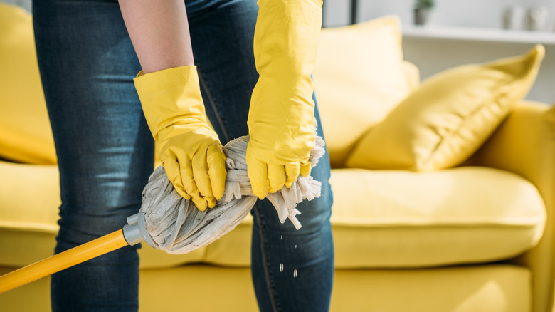 Gloved hands wringing mop