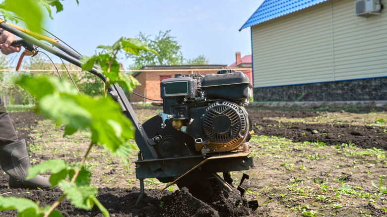 Person using a machine to till the ground