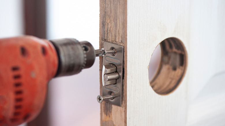 Person installing deadbolt