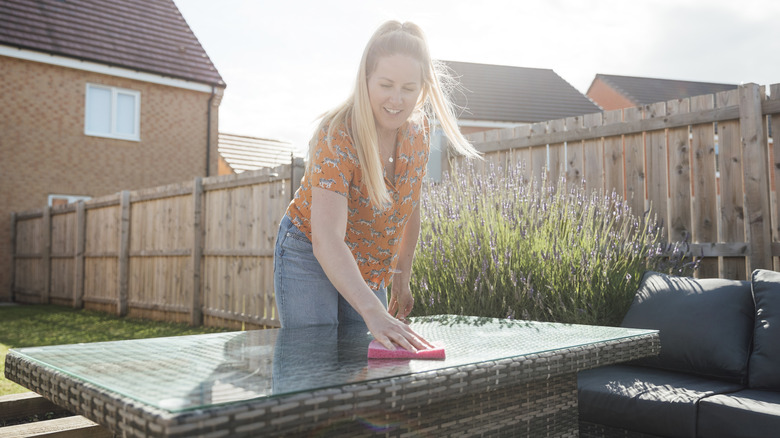 woman cleaning outdoor furniture