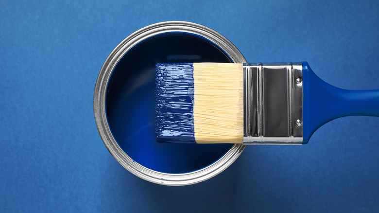 Can of blue paint with brush