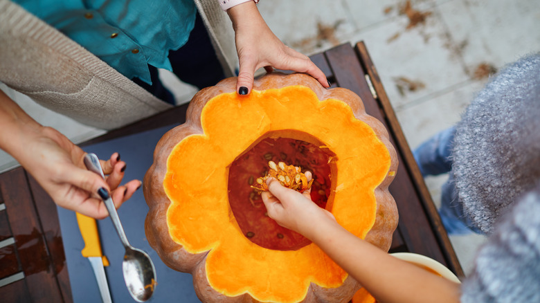 scooping pumpkin seeds