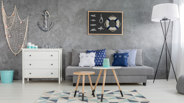 Nautical-themed living room with anchors, nets, robes, and other decor