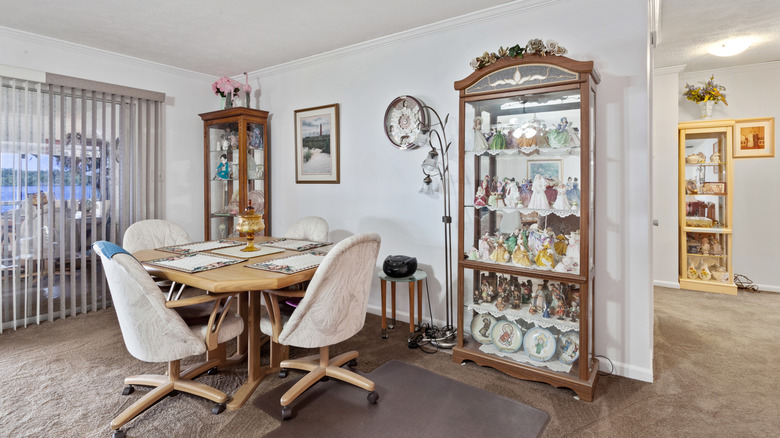 Three curio cabinets with dolls and dinnerware in a living space