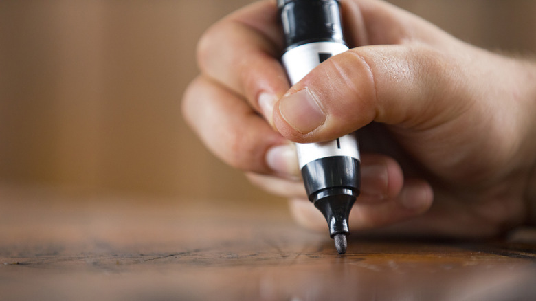 permanent marker on dark surface 