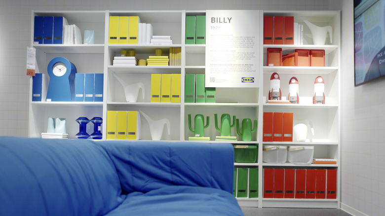 A white IKEA Billy bookshelf, on display with a written plaque at an event.