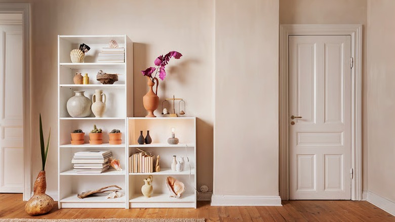 Two adjacent white BILLY bookcases, ornamented with terracotta vases and other pottery.