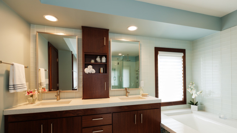 A bathroom featuring a timber vanity unit and a recessed timber medicine cabinet