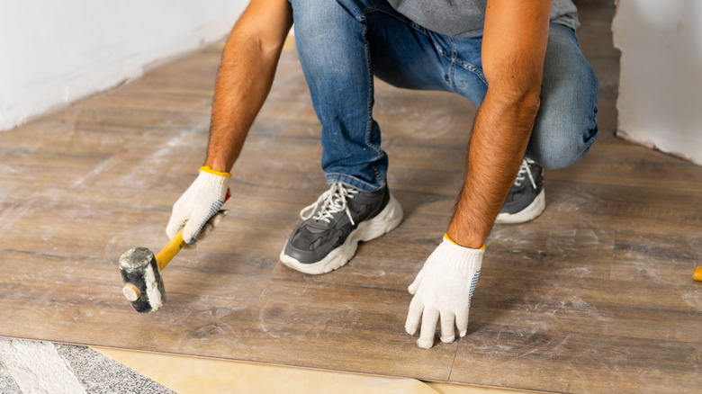 person installing floorboards