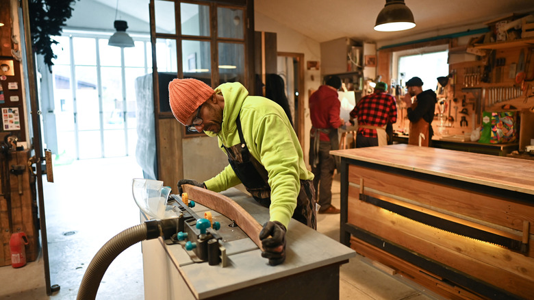 A carpenter creating a piece of furniture in a workshop.