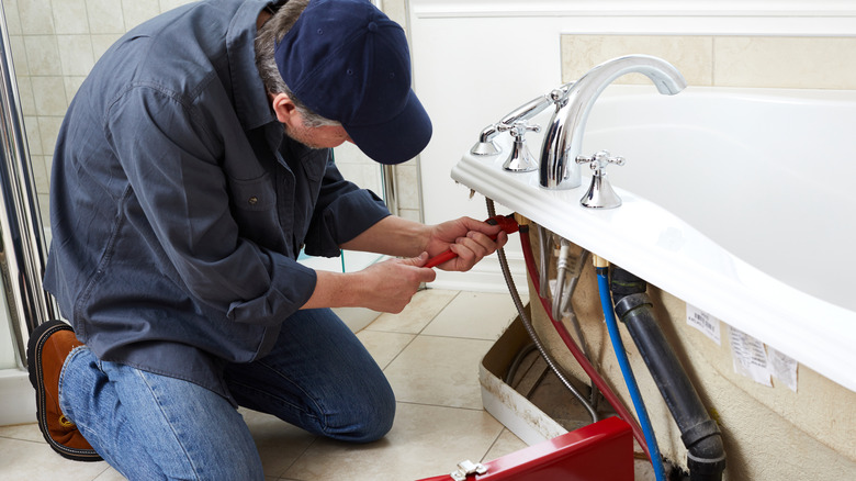 technician repairing bathtub