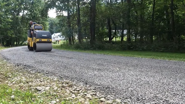 Person finishing a chip and seal driveway