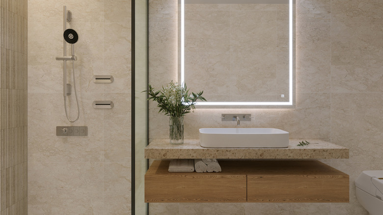 Modern bathroom with floating vanity, exposed shower, and brown and beige color palette
