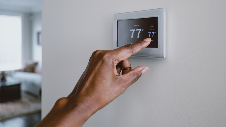 Close-up of hand adjusting thermostat