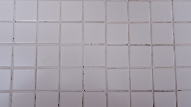 White tile and grout with dirt in it