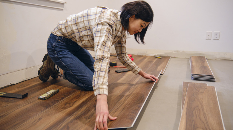 Woman installing flooring