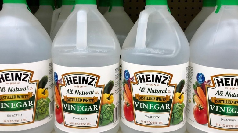 Heinz All Natural Distilled White Vinegar bottles on store shelf.