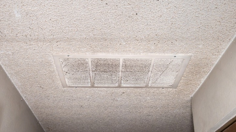 Dirty popcorn ceiling with HVAC intake