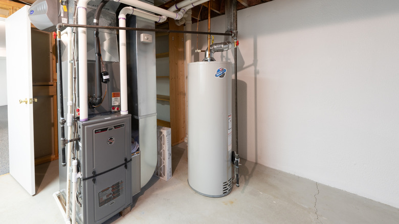 Home water heater next to a furnace in a basement setting