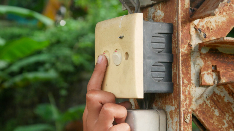 A person turns off their outdoor lights.