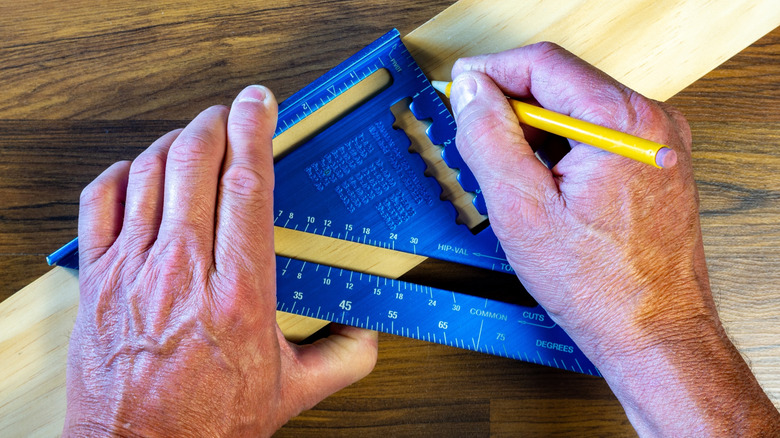 Person using a speed square on a 2-by-4