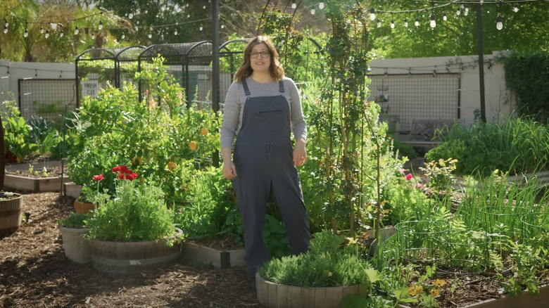 woman standing in a large outdoor container garden