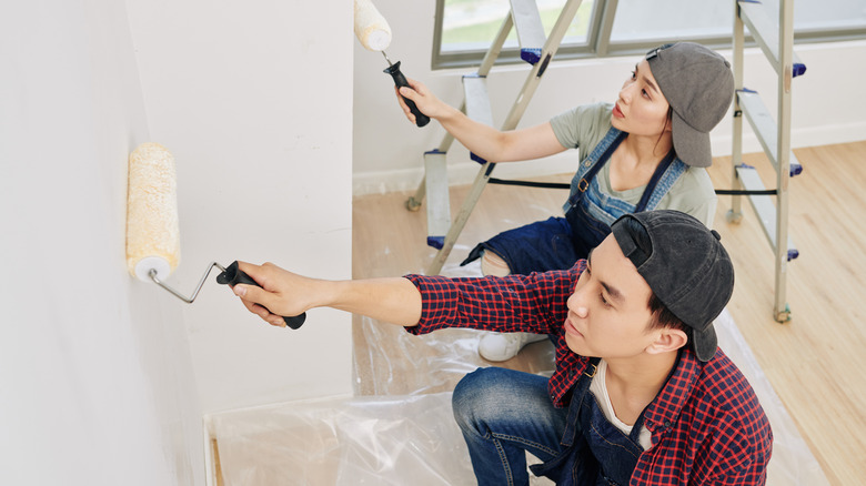 Couple painting house